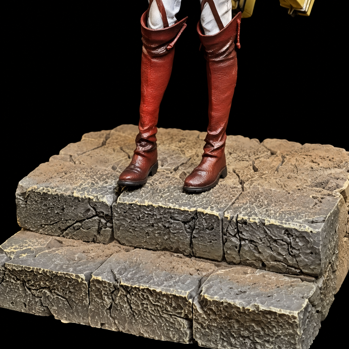 Détail du socle rocheux et des bottes de la figurine Annie
