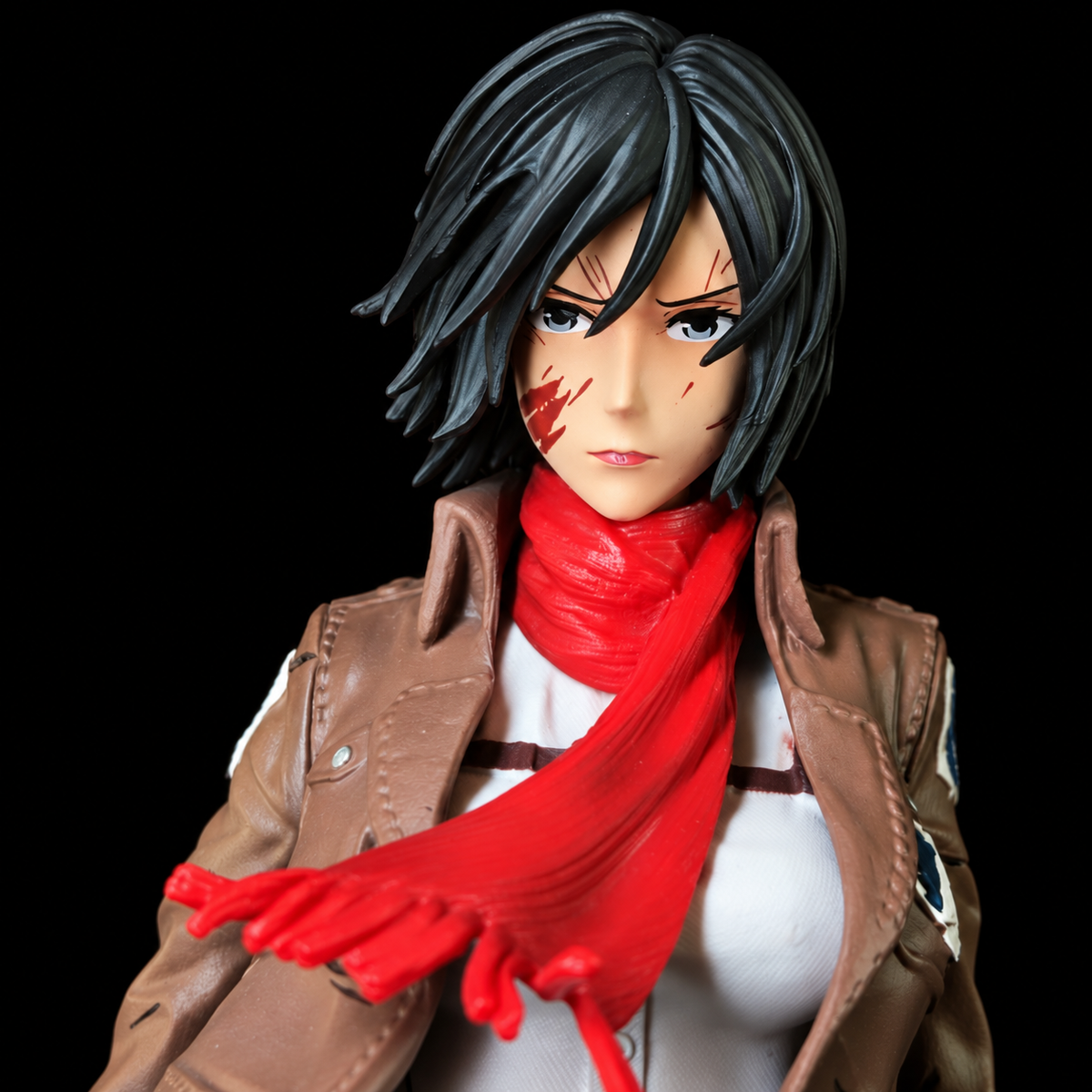 Gros plan du visage de Mikasa avec son écharpe rouge