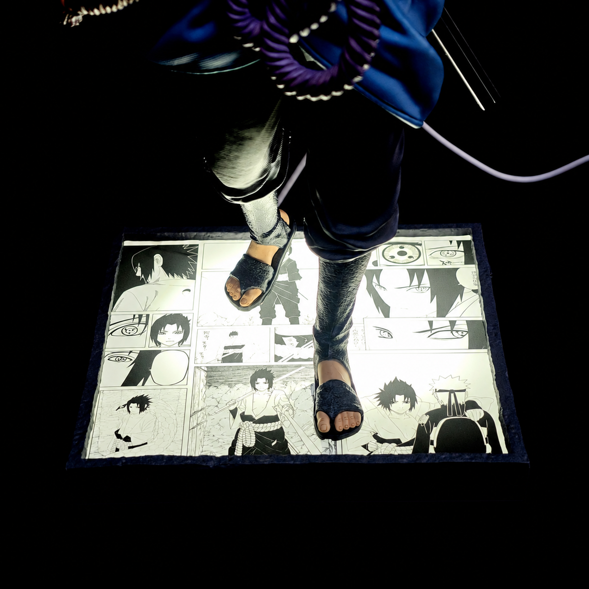 Détail du socle lumineux illustré de la figurine Sasuke